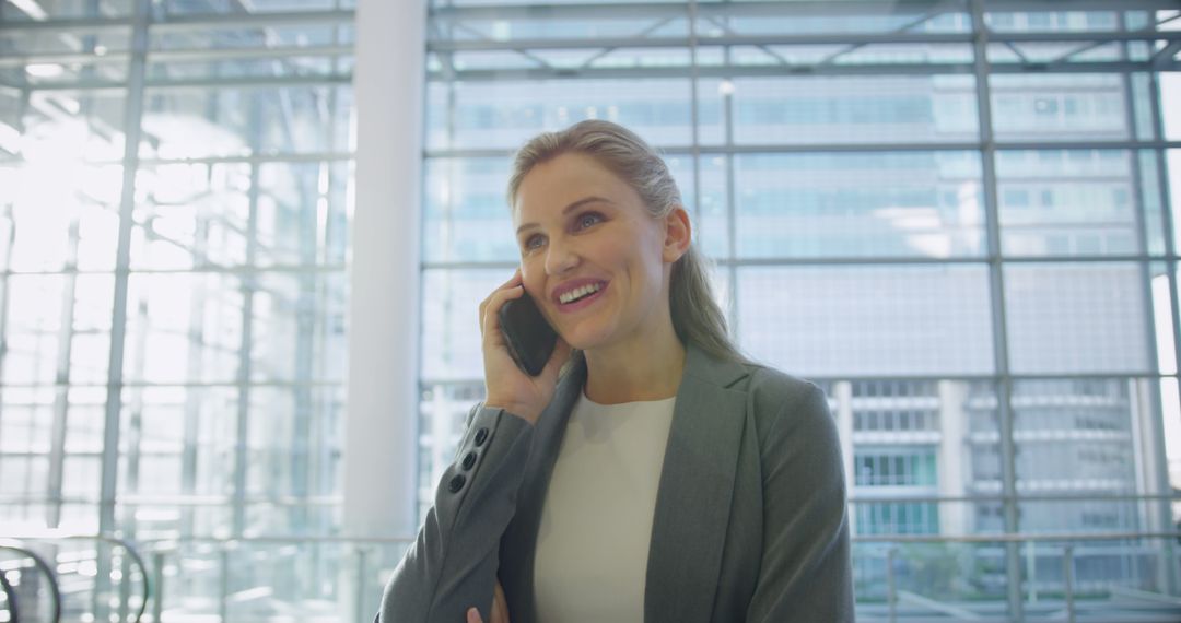 Confident Businesswoman Smiling During Phone Call in Modern Office - Free Images, Stock Photos and Pictures on Pikwizard.com