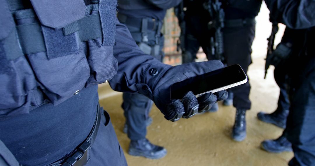 SWAT Team Member Holding Mobile Phone During Operation - Free Images, Stock Photos and Pictures on Pikwizard.com