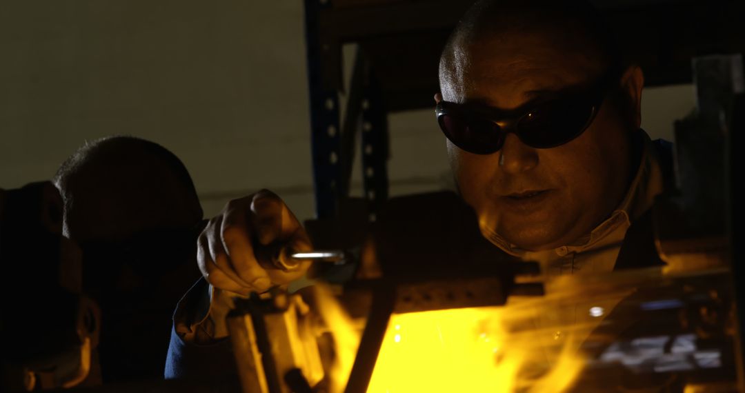 Industrial Worker Welding Metal with Goggles in Dimly Lit Workshop - Free Images, Stock Photos and Pictures on Pikwizard.com