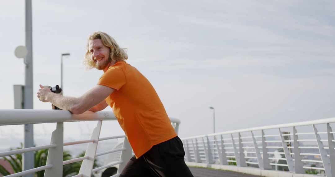 Smiling Man with Blonde Hair Exercising on Bridge - Free Images, Stock Photos and Pictures on Pikwizard.com