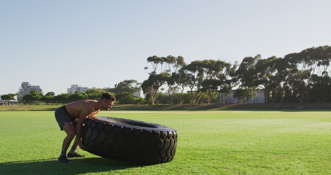 Athletic Man Flipping Large Tire in Outdoor Park - Free Images, Stock Photos and Pictures on Pikwizard.com