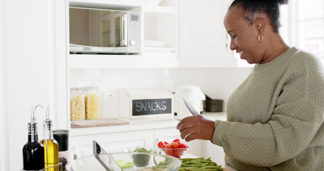 Smiling Woman Preparing Fresh Vegetables in Modern Kitchen - Free Images, Stock Photos and Pictures on Pikwizard.com