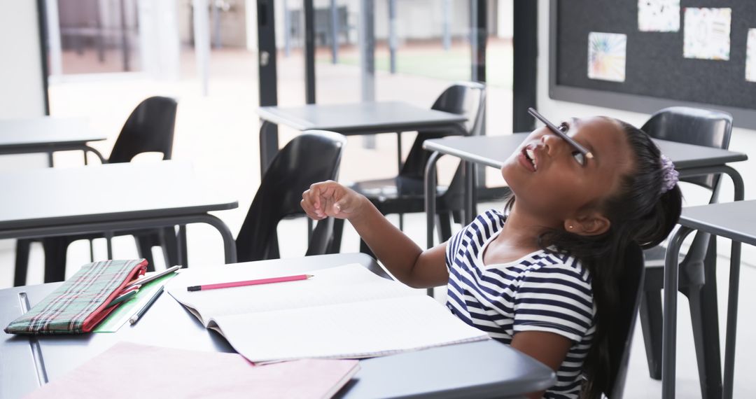 Child Engaging in Classroom Fun Balancing Pencil on Nose