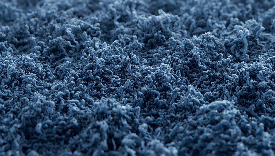Revealing blue shag carpet macro texture with twisted yarn pile and plush tufted fibers