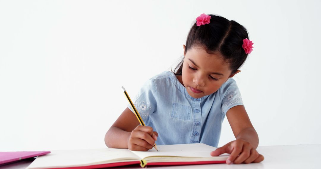 Young Girl Focused on Schoolwork in Classroom - Free Images, Stock Photos and Pictures on Pikwizard.com