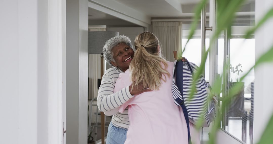 Happy Senior Woman Hugging Adult Daughter in Entryway - Free Images, Stock Photos and Pictures on Pikwizard.com