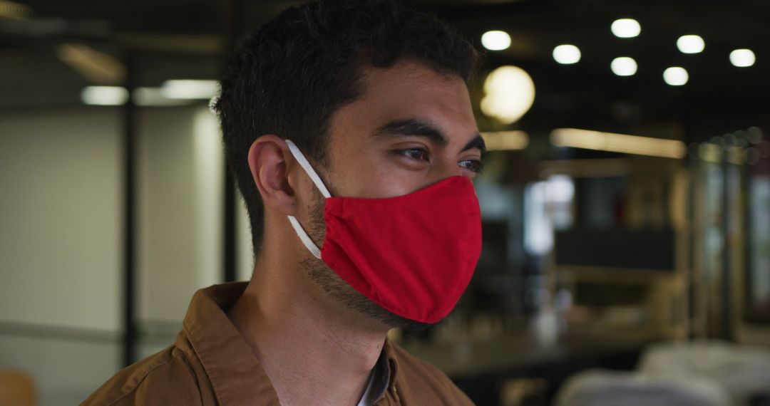 Young Man Wearing Red Face Mask in Workplace - Free Images, Stock Photos and Pictures on Pikwizard.com