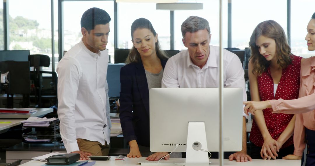 Diverse Team Collaborating on Computer in Contemporary Office Environment