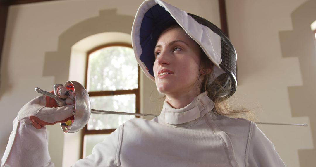 Female Fencer Holding Épée in Sunlit Room - Free Images, Stock Photos and Pictures on Pikwizard.com