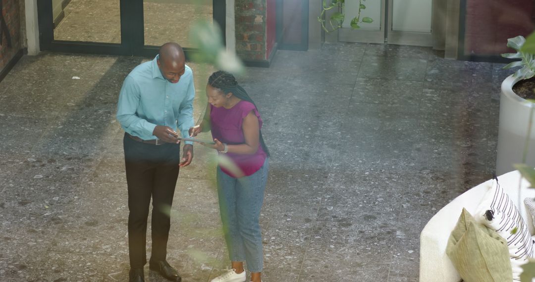 Diverse Colleagues Collaborating with Tablet in Modern Office Space