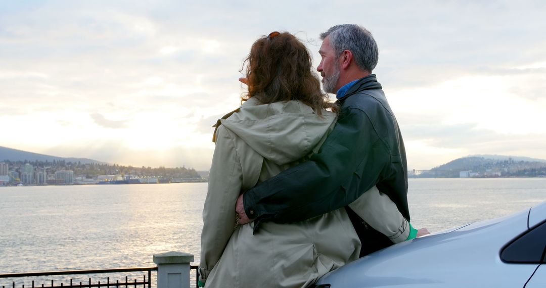 A middle-aged Caucasian couple enjoys a scenic view of a waterfront at sunset, with copy space - Free Images, Stock Photos and Pictures on Pikwizard.com