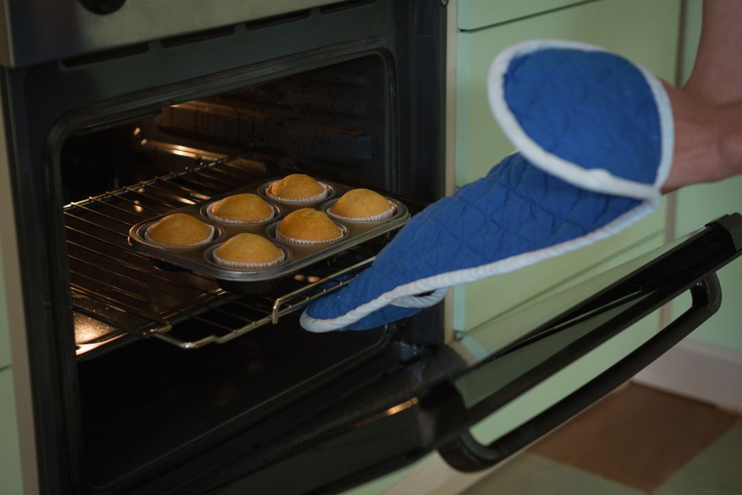 Woman putting muffins in oven - Free Images, Stock Photos and Pictures on Pikwizard.com