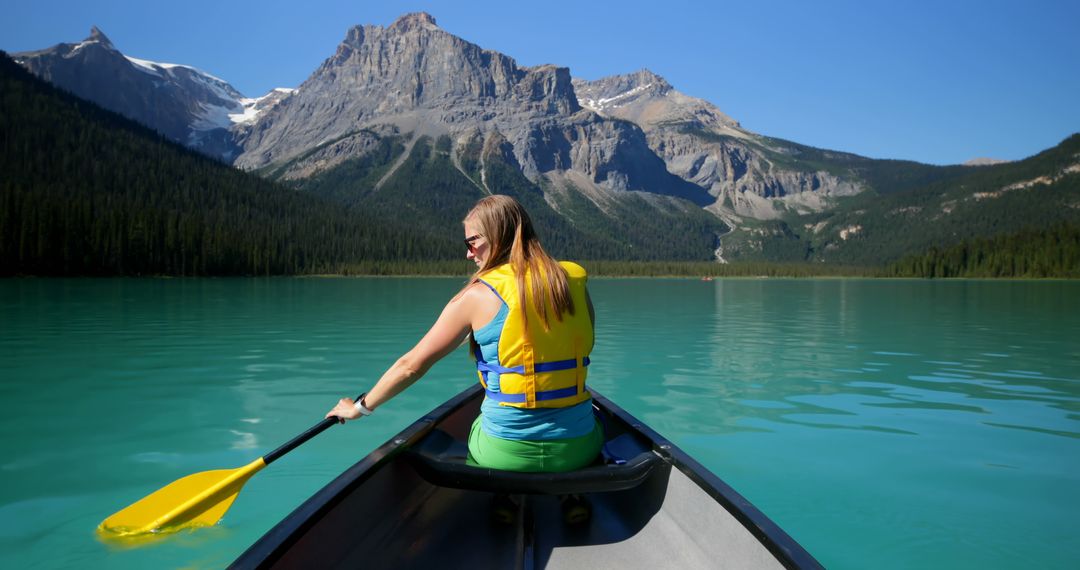 Woman Canoeing on Scenic Mountain Lake with Turquoise Water - Free Images, Stock Photos and Pictures on Pikwizard.com