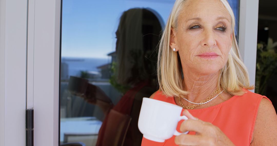 Elderly Woman Drinking Coffee Outdoors with a Thoughtful Expression - Free Images, Stock Photos and Pictures on Pikwizard.com