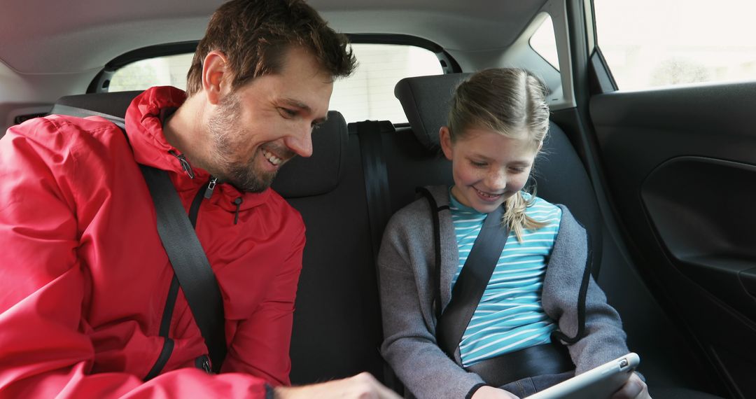 Father and Daughter Riding in Car Backseat Enjoying Tablet - Free Images, Stock Photos and Pictures on Pikwizard.com