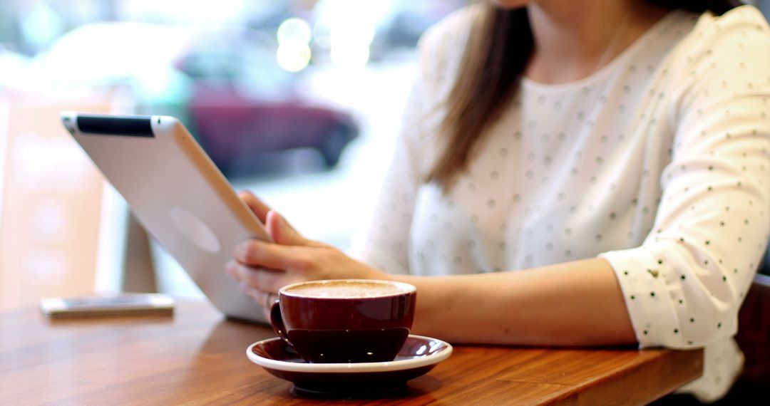 Woman Reading Tablet with Coffee at Cafe Table - Free Images, Stock Photos and Pictures on Pikwizard.com