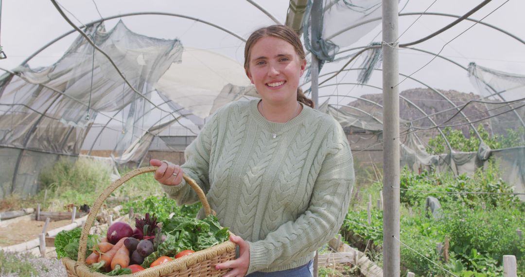 Smiling Woman Holding Basket of Fresh Vegetables in Greenhouse - Free Images, Stock Photos and Pictures on Pikwizard.com