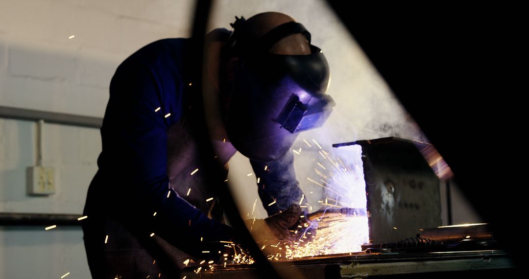 Professional Welder Wearing Protective Gear Inside Industrial Workshop - Free Images, Stock Photos and Pictures on Pikwizard.com