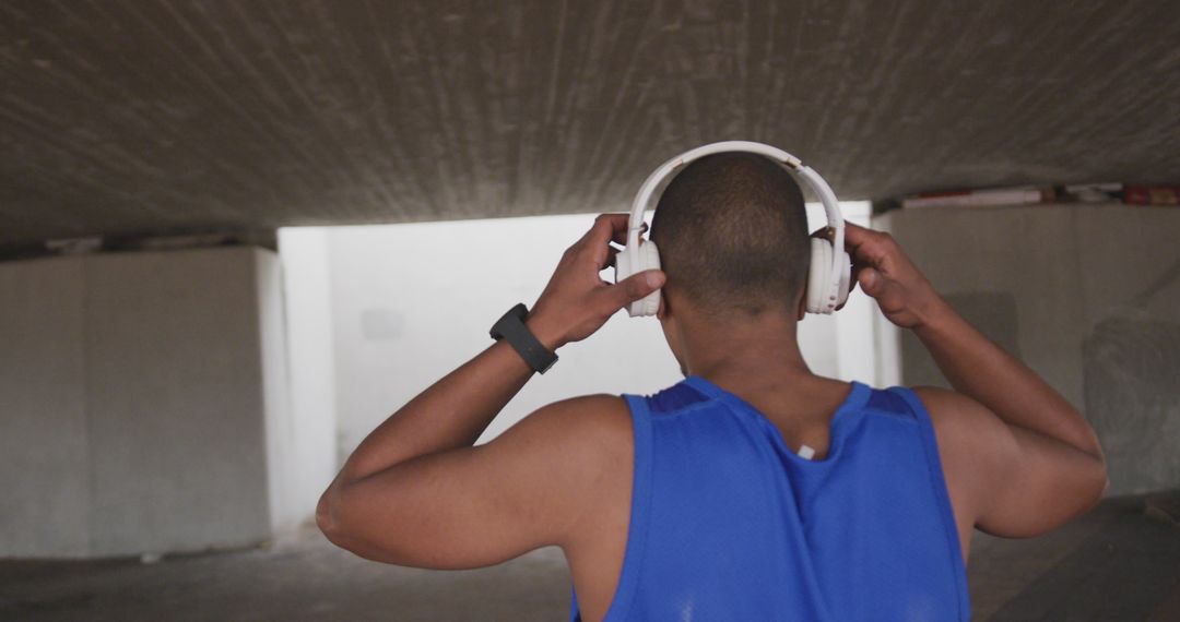 Man Adjusting Headphones and Preparing for Workout Outdoors - Free Images, Stock Photos and Pictures on Pikwizard.com