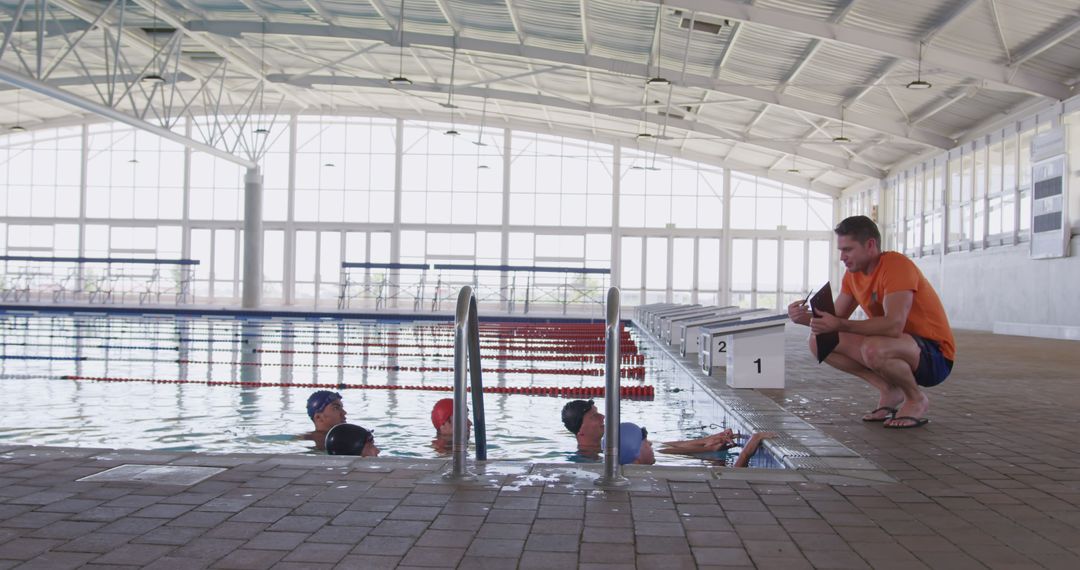 Swimming Coach Training Young Swimmers at Indoor Pool - Free Images, Stock Photos and Pictures on Pikwizard.com