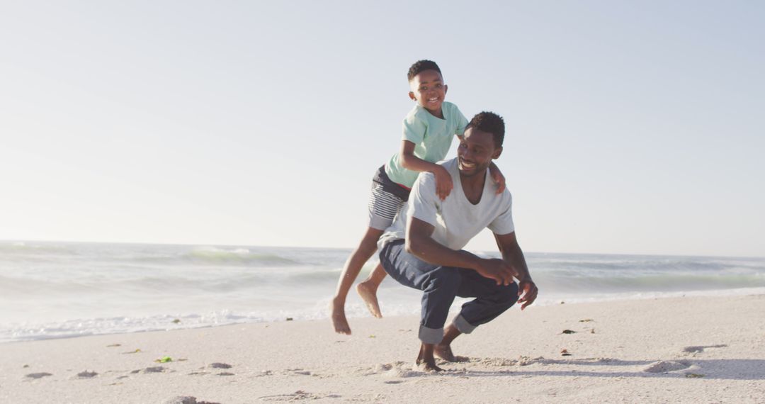 Father and son enjoying playful moment on beach - Free Images, Stock Photos and Pictures on Pikwizard.com