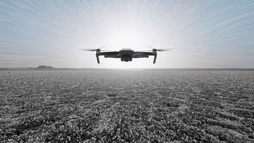 Backlit Quadcopter Hovering Over Salt Flat with Sun Halo and Radial Light Streaks
