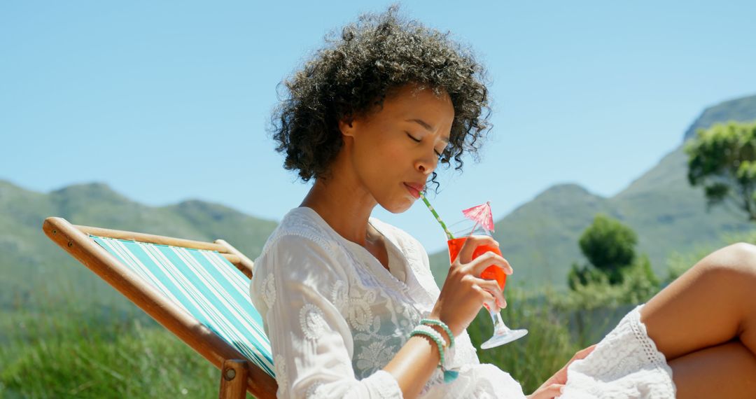 Young woman enjoying a refreshing drink on vacation - Free Images, Stock Photos and Pictures on Pikwizard.com