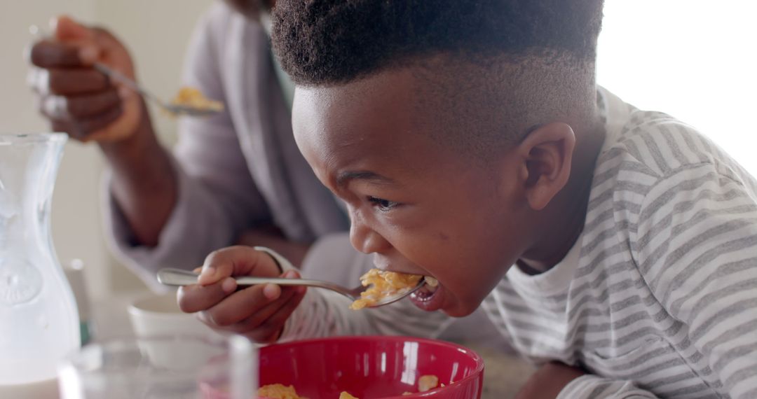 Young Boy Eating Breakfast Cereal with Enthusiasm - Free Images, Stock Photos and Pictures on Pikwizard.com