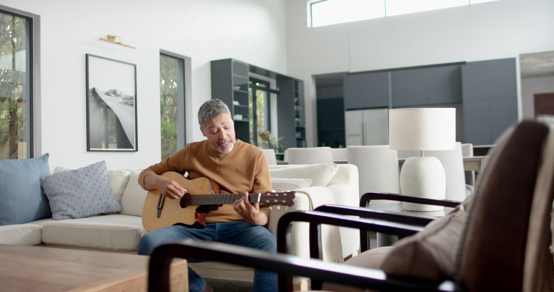 Mature Man Playing Acoustic Guitar in Modern Living Room - Free Images, Stock Photos and Pictures on Pikwizard.com