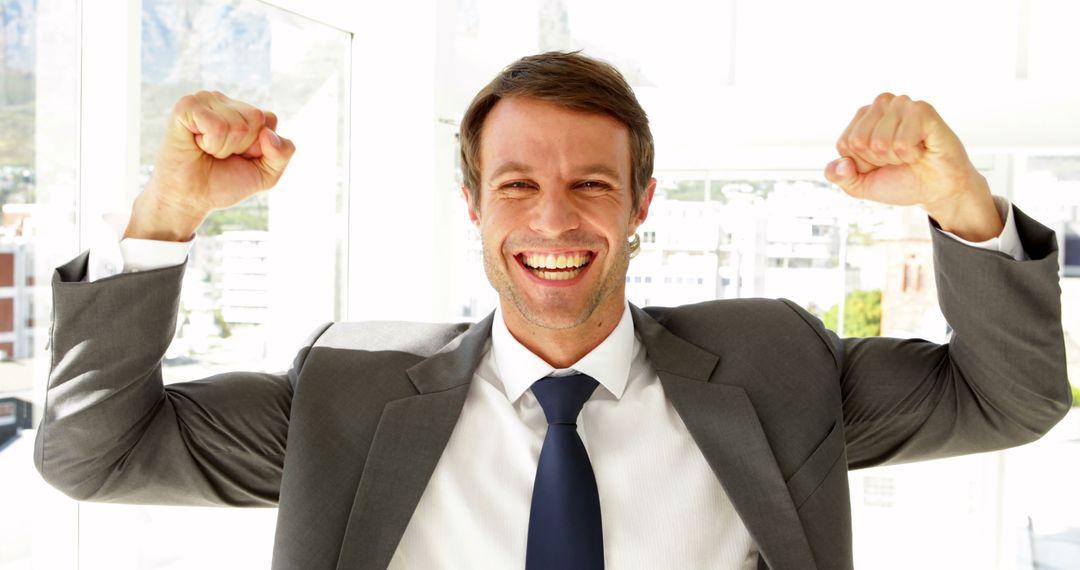 Businessman Celebrating Success with Raised Fists - Free Images, Stock Photos and Pictures on Pikwizard.com