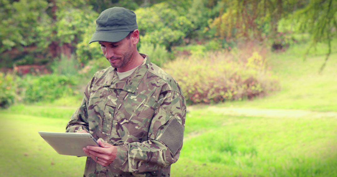 Soldier in Camouflage Uniform Using Tablet in Outdoor Setting - Free Images, Stock Photos and Pictures on Pikwizard.com