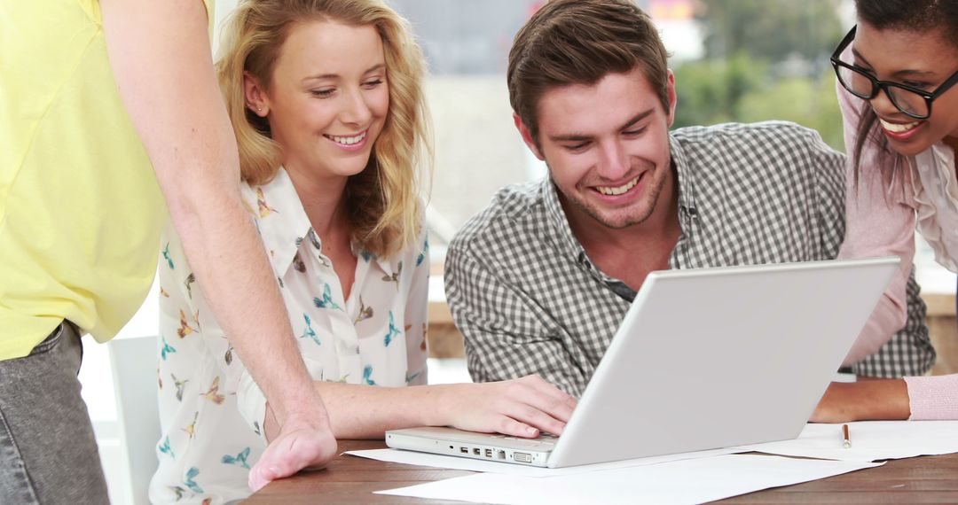 Young Professionals Engaging in Collaborative Meeting with Laptop