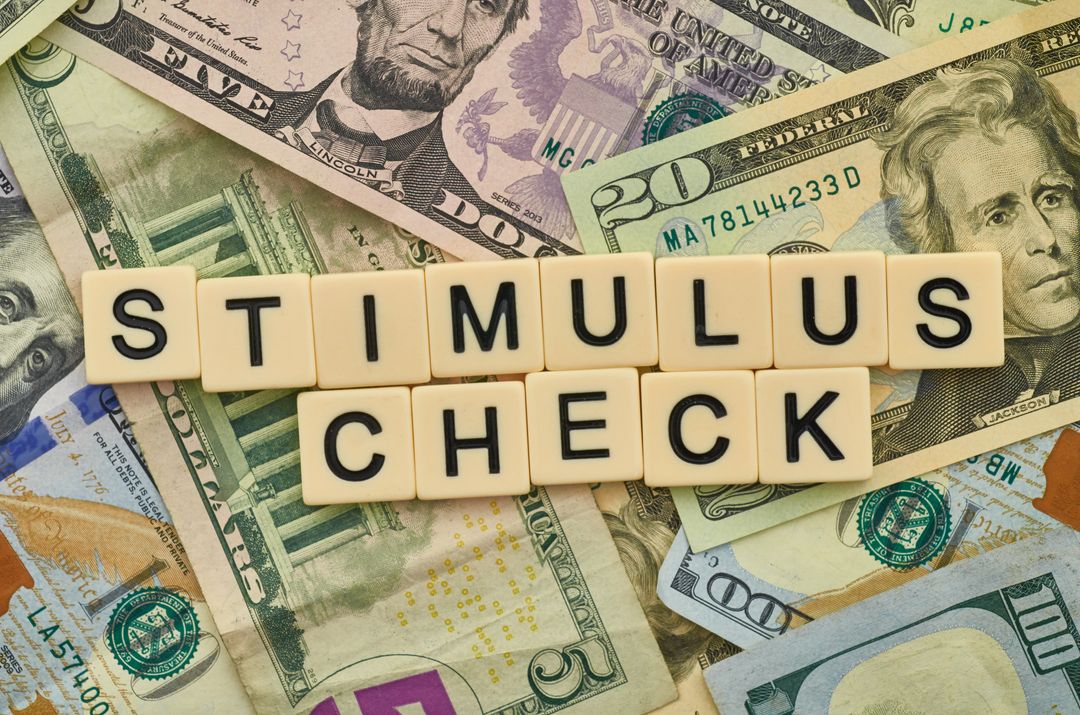 Stimulus Check Concept on US Dollar Bills Background