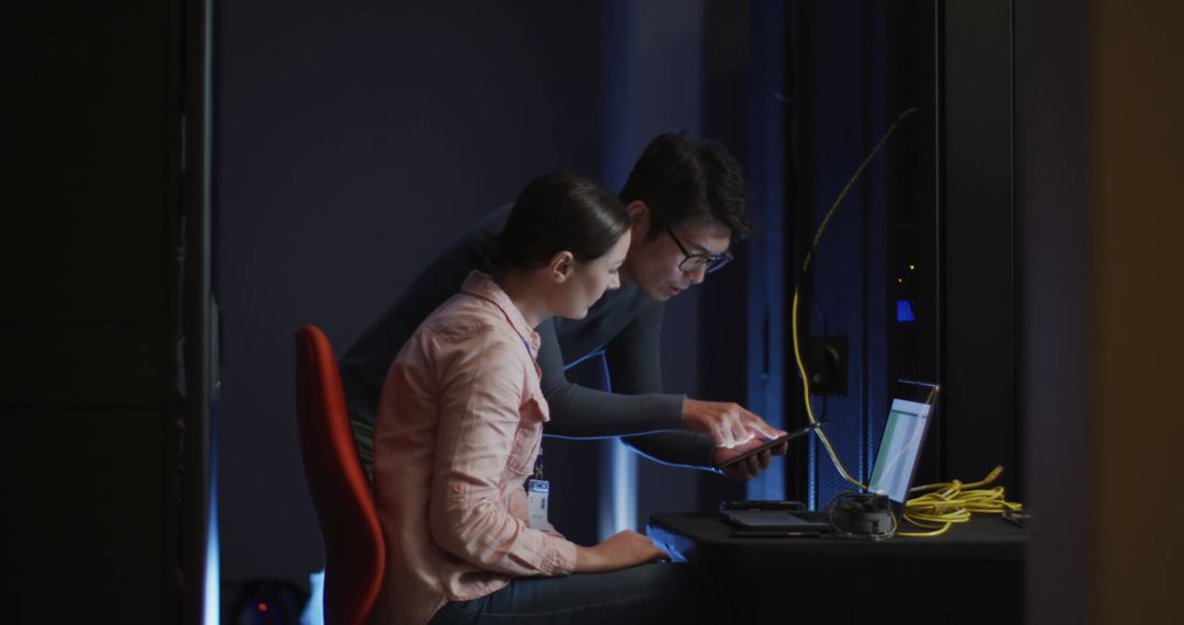 Professionals Analyzing Data in Server Room Environment