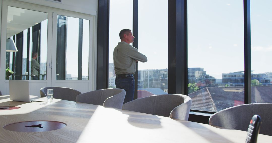 Businessman reflecting while looking out office window - Free Images, Stock Photos and Pictures on Pikwizard.com