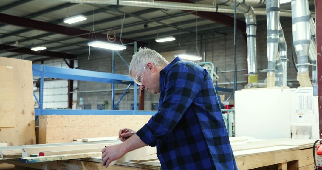 Carpenter Measuring Wood in Workshop Wearing Flannel Shirt and Safety Glasses - Free Images, Stock Photos and Pictures on Pikwizard.com