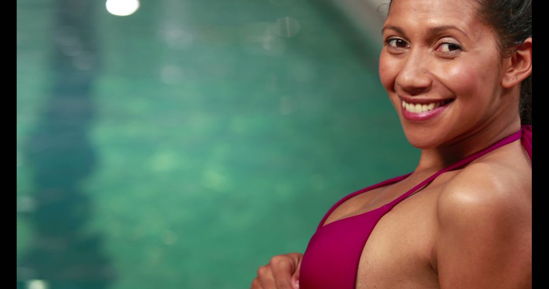A smiling woman in a swimsuit stands by a pool, with copy space - Free Images, Stock Photos and Pictures on Pikwizard.com
