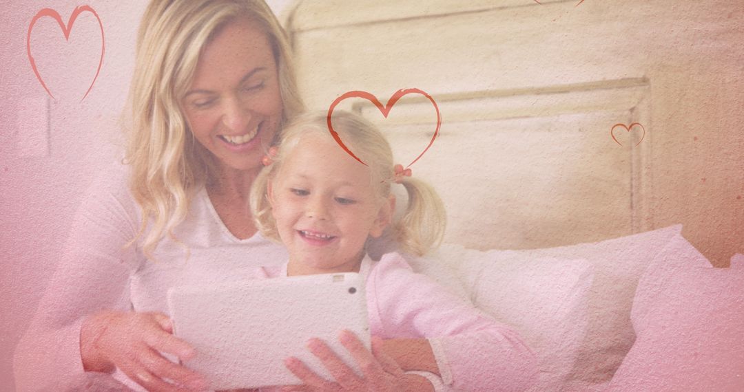Mother and Daughter Using Tablet with Heart Motif Overlay