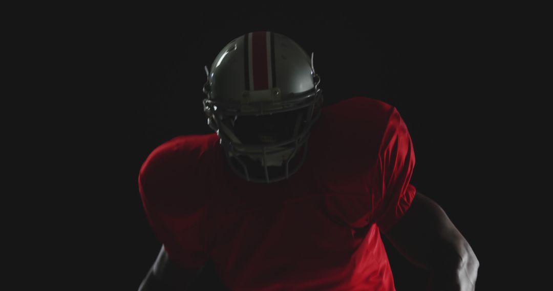 Football Player in Red Jersey Against Dark Background - Free Images, Stock Photos and Pictures on Pikwizard.com