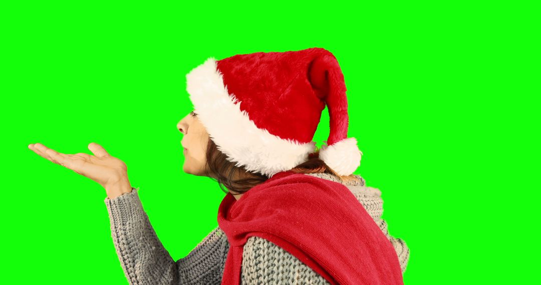 Woman Blowing Kiss Wearing Santa Hat with Green Background - Free Images, Stock Photos and Pictures on Pikwizard.com