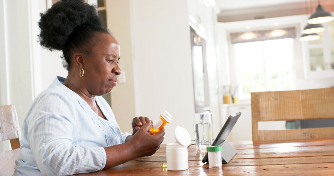 Senior Woman Taking Medication while Watching Digital Tablet - Free Images, Stock Photos and Pictures on Pikwizard.com