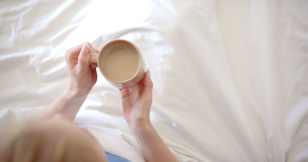 Woman Relaxing with Coffee in Bed Showing Cozy Morning Routine
