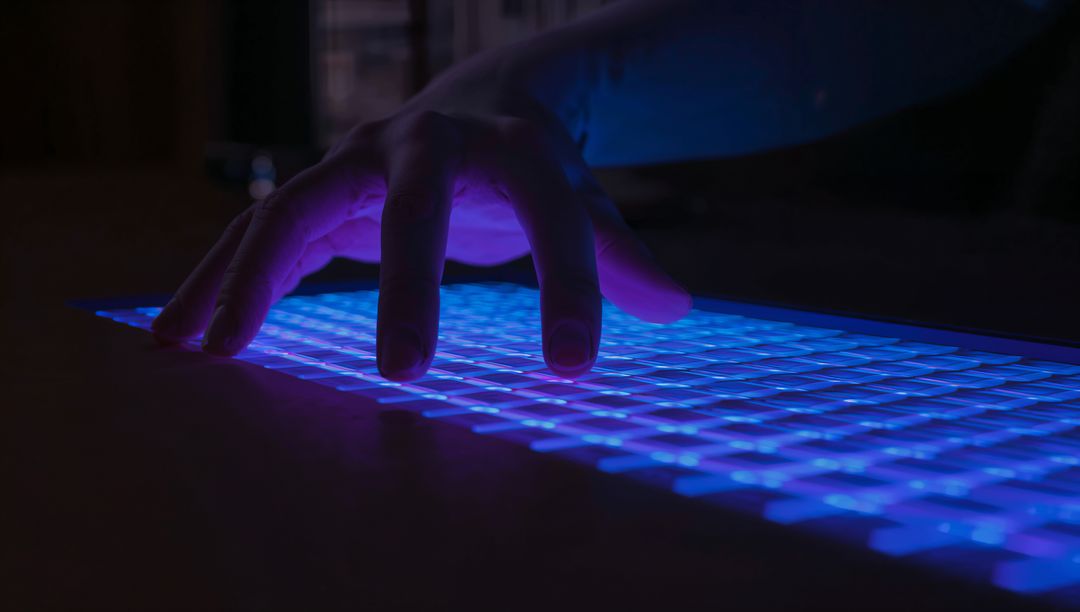 Hand Hovering Over Illuminated Blue Purple Backlit Keyboard Futuristic Cyber Tech Concept