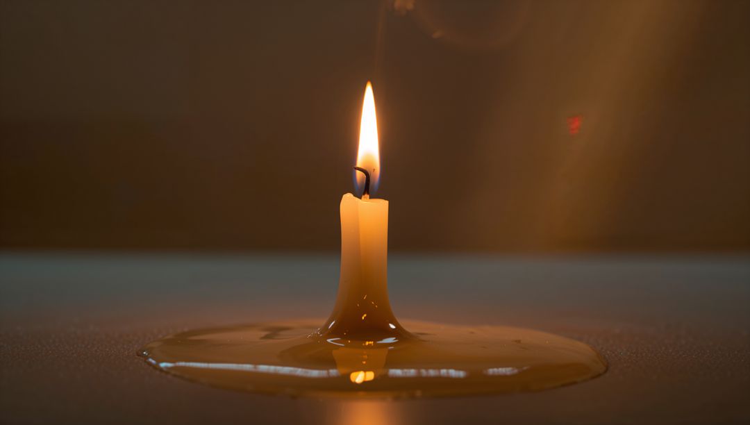 Solitary Burning Candle with Melted Wax Pooling