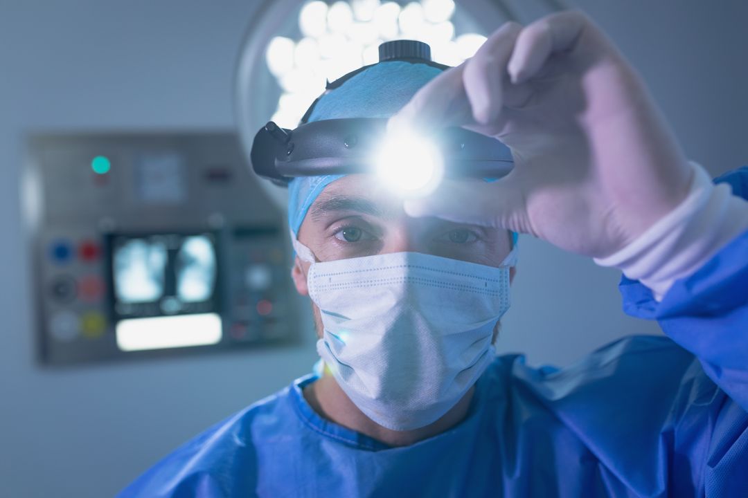 Male surgeon holding surgical headlamp in operating room - Free Images, Stock Photos and Pictures on Pikwizard.com
