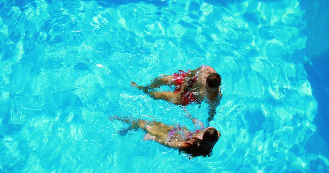 Two Girls Swimming in Pool with Clear Blue Water - Free Images, Stock Photos and Pictures on Pikwizard.com