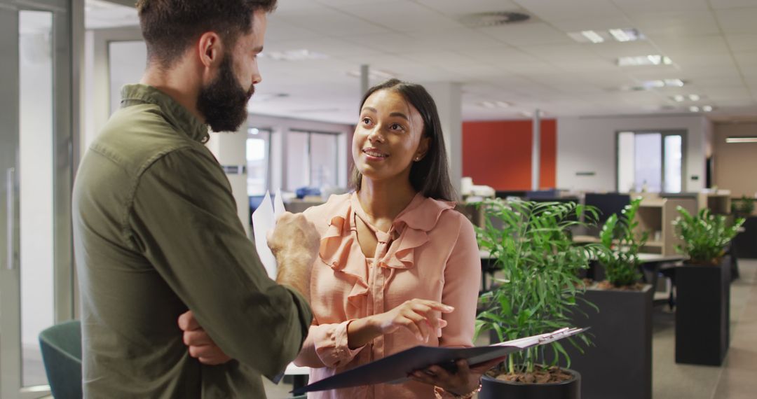 Diverse Business Professionals Discussing Work in Modern Office Environment