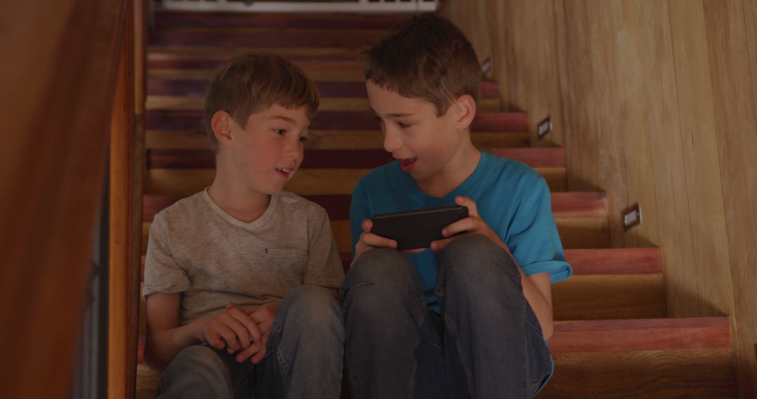 Two Boys Sitting on Stairs Watching Tablet Screen Together Indoors - Free Images, Stock Photos and Pictures on Pikwizard.com