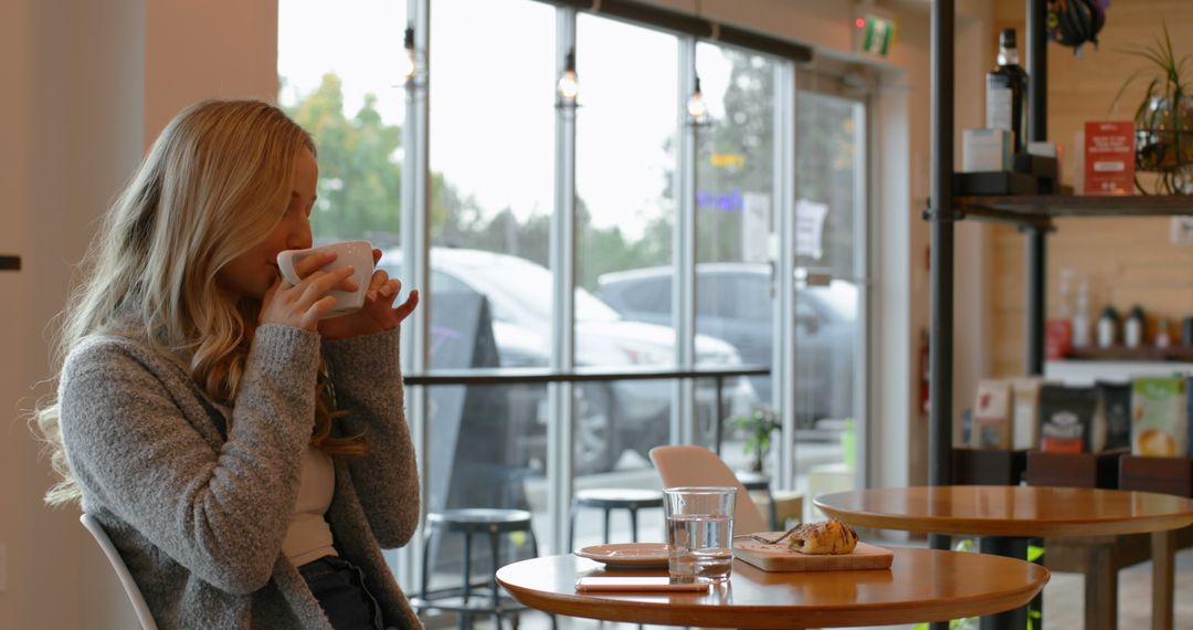 Woman Enjoying Hot Coffee at Cozy Café - Free Images, Stock Photos and Pictures on Pikwizard.com