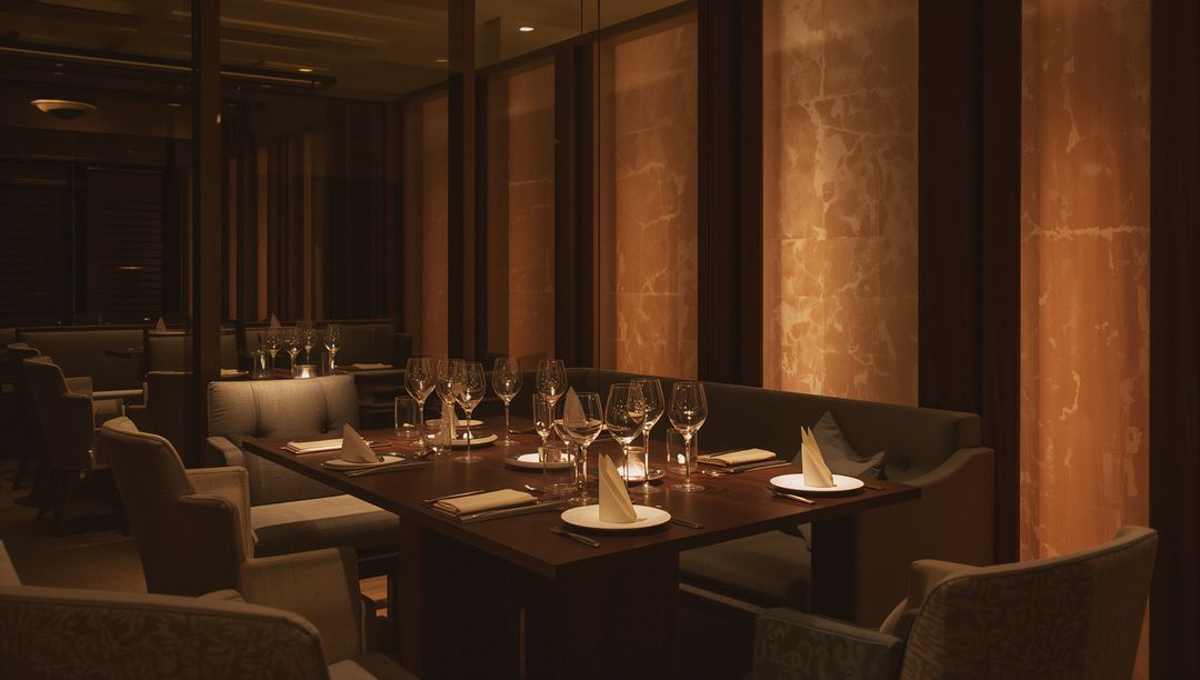 Intimate candlelit private dining table glowing with crystal glassware and marble columns